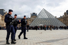 Príslušníci francúzskej poriadkovej polície kráčajú pri sklenenej pyramíde v múzeu Louvre. FOTO: Reuters