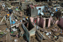 Na snímke ľudia sa vracajú do svojich domovov, ktoré zničil tajfún Kalmaegi na Filipínach 5. novembra 2025. FOTO: TASR/AP