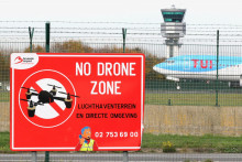 Lietadlo pristáva na pristávacej dráhe v blízkosti transparentu „Zóna bez dronov“. FOTO: Reuters