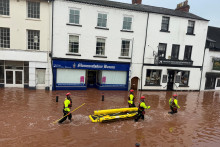 Záchranári sa brodia záplavovou vodou počas severných záplav v južnom Walese. FOTO: Reuters