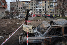 Obyvatelia prijímajú humanitárnu pomoc v blízkosti svojho bytového domu poškodeného počas ruských raketových útokov  v meste Balaklija v Charkovskej oblasti. FOTO: Reuters