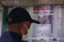 Muž si číta noviny, v ktorých sa píše o výrokoch japonskej premiérky Sanae Takaičiovej v novinovom stánku v Pekingu. FOTO: TASR/AP