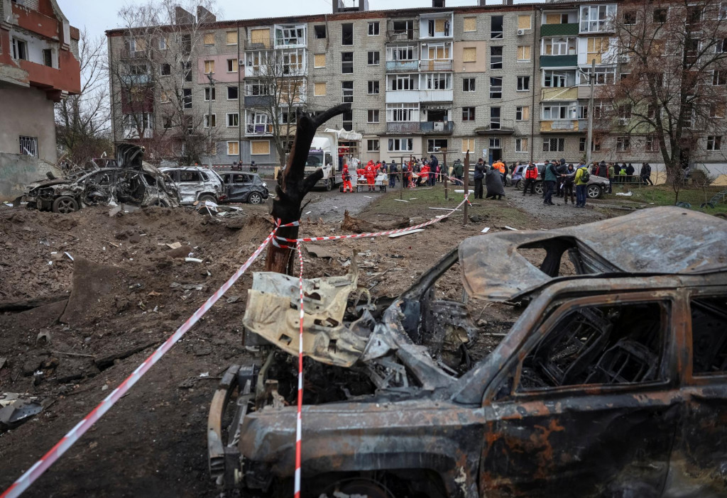 Obyvatelia prijímajú humanitárnu pomoc v blízkosti svojho bytového domu poškodeného počas ruských raketových útokov  v meste Balaklija v Charkovskej oblasti. FOTO: Reuters