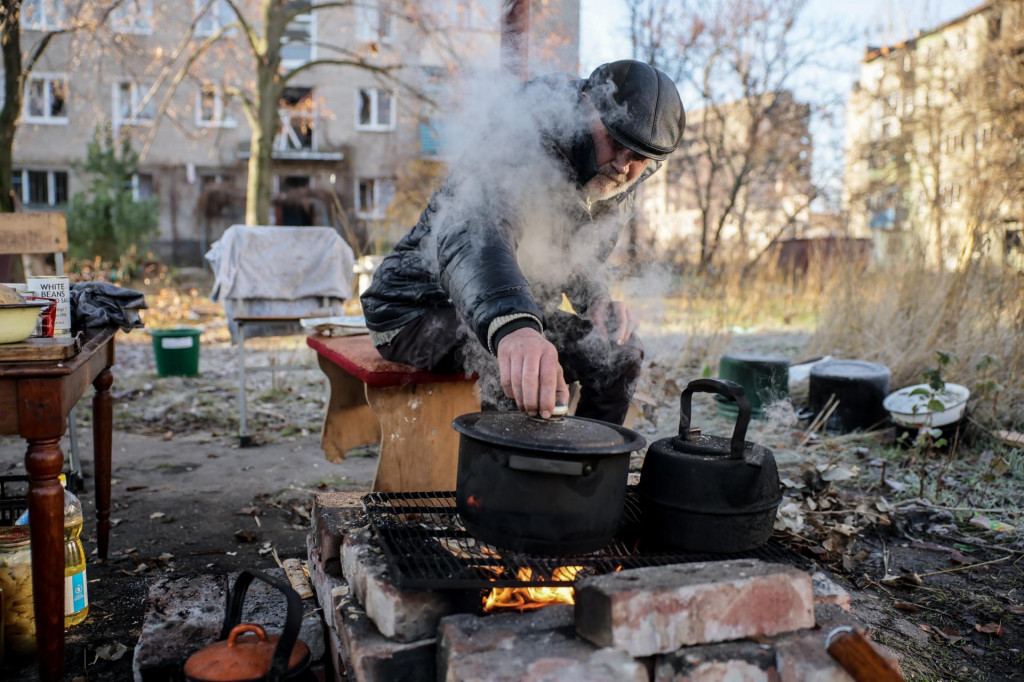Miestny obyvateľ varí na otvorenom ohni na ulici pred zničenou obytnou budovou v dedine Konstantinivka pri meste Kramatorsk, v Doneckom regióne. FOTO: TASR/AP