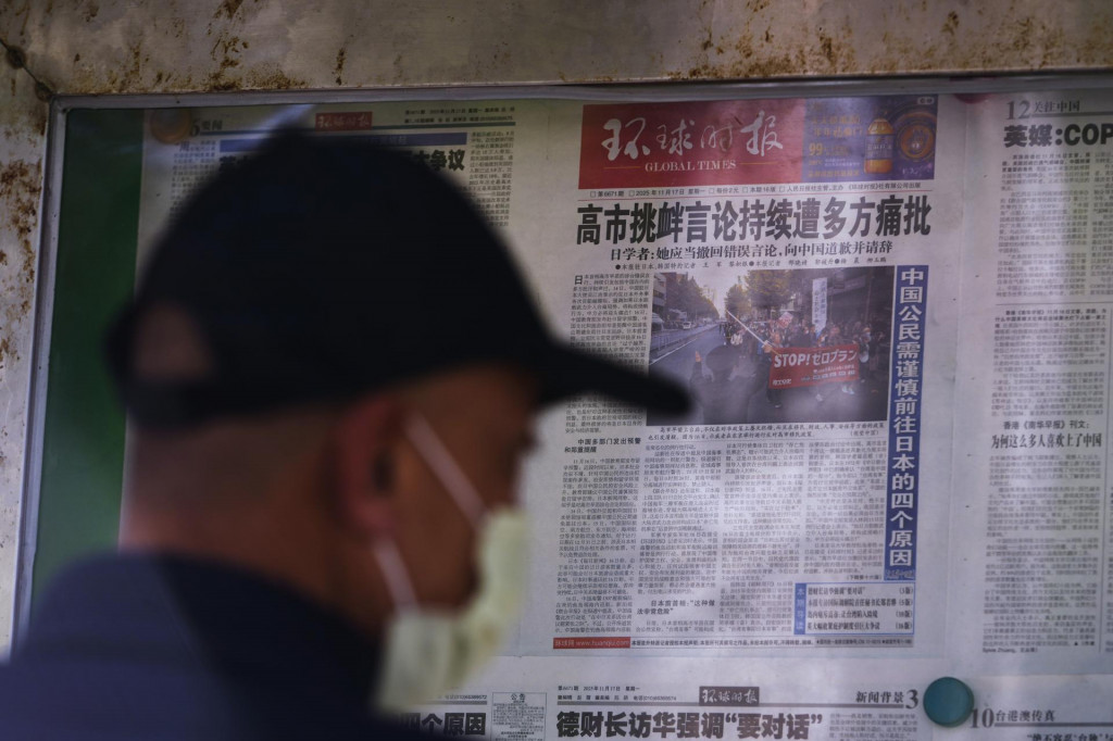 Muž si číta noviny, v ktorých sa píše o výrokoch japonskej premiérky Sanae Takaičiovej v novinovom stánku v Pekingu. FOTO: TASR/AP