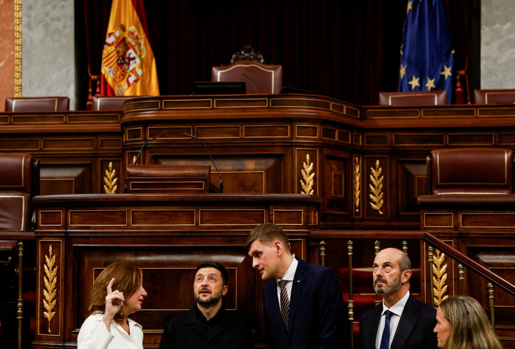 Ukrajinský prezident Volodymyr Zelenskyj sa pozerá na diery po guľkách v strope z pokusu o prevrat z 23. februára 1981 počas návštevy španielskeho parlamentu s predsedníčkou Kongresu poslancov Francinou Armengolovou a predsedom Senátu Pedrom Rollanom. FOTO: Reuters