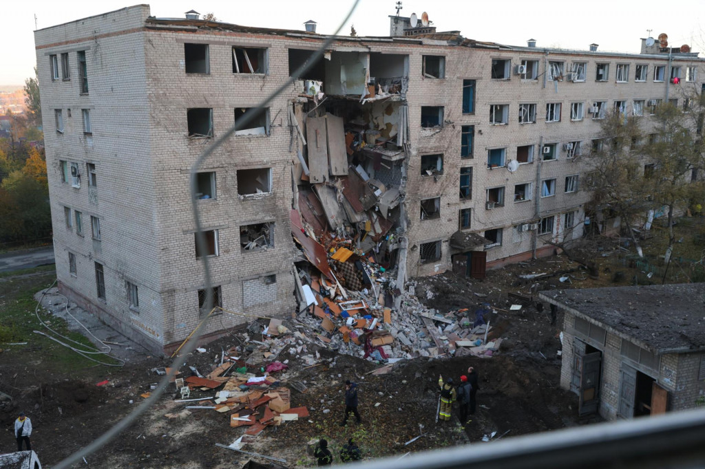 Záchranári prehľadávajú trosky hostela, ktorý zasiahol raketový útok ruskej armády v ukrajinskom meste Záporožie. FOTO: TASR/AP