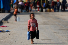 Palestínske dieťa nesie nádoby s vodou v meste Gaza. FOTO: Reuters