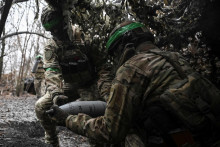 Ukrajinskí vojaci nesú náboj pre húfnicu, zatiaľ čo sa pripravujú na paľbu na ruské jednotky neďaleko mesta Pokrovsk. FOTO: Reuters