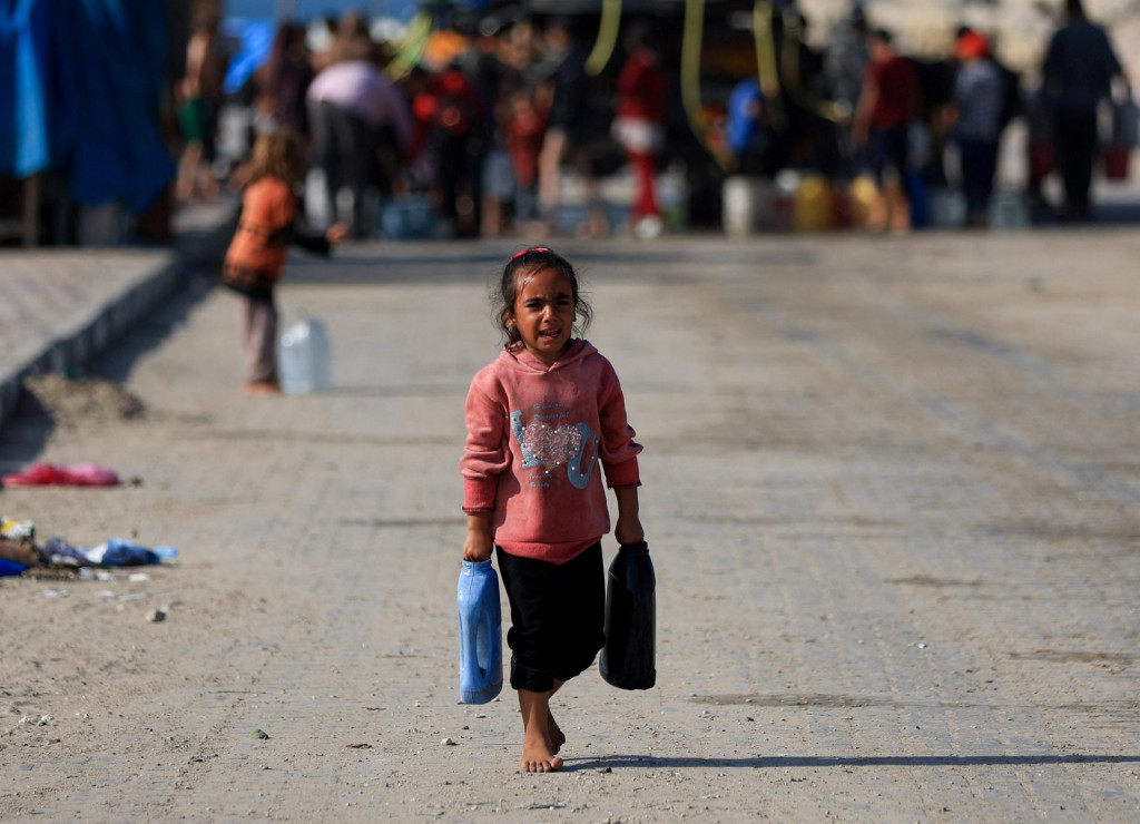 Palestínske dieťa nesie nádoby s vodou v meste Gaza. FOTO: Reuters