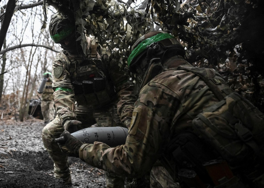 Ukrajinskí vojaci nesú náboj pre húfnicu, zatiaľ čo sa pripravujú na paľbu na ruské jednotky neďaleko mesta Pokrovsk. FOTO: Reuters