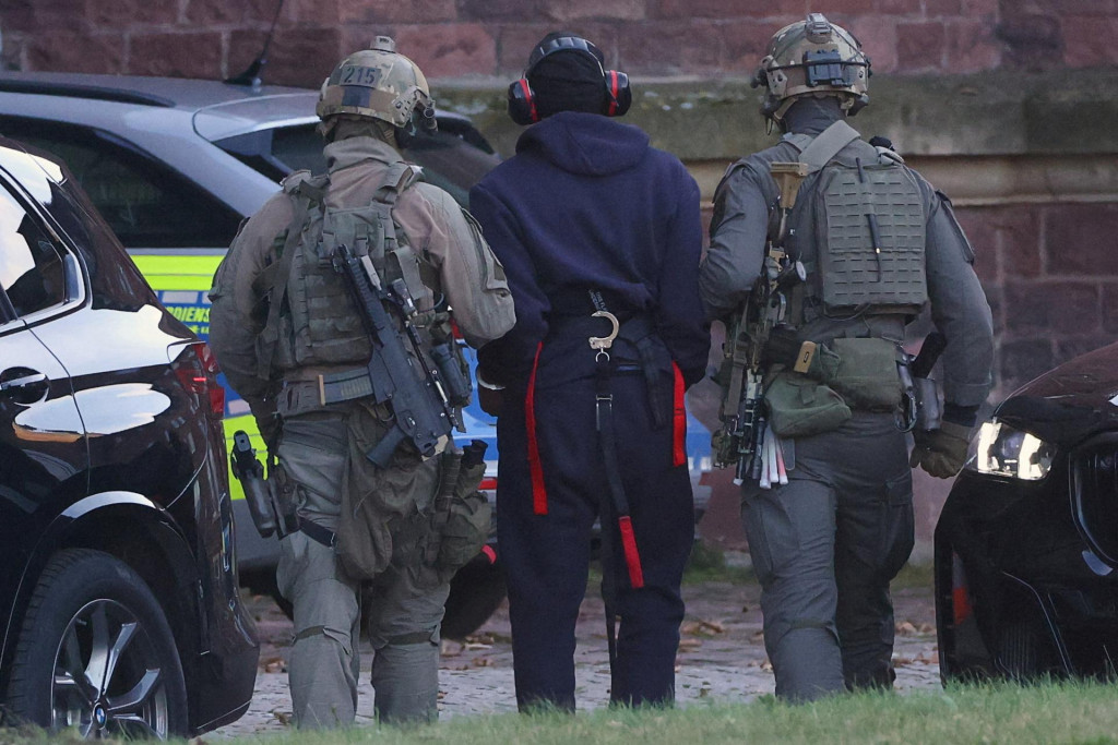 Polícia eskortuje Ukrajinca S.K. z vrtuľníka pred vypočutím s nemeckým federálnym prokurátorom. FOTO: Reuters
