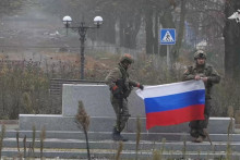 Na snímke z videa ruskí vojaci s vlajkou v Pokrovsku. Video bolo zverejnené 1. decembra 2025. Agentúre Reuters sa podarilo overiť polohu, ale nie dátum vytvorenia. FOTO: REUTERS/Russian Defence Ministry