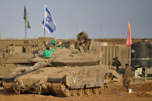 Izraelskí vojaci pracujú na svojich tankoch neďaleko hranice Izraela s Pásmom Gazy. FOTO: TASR/AP