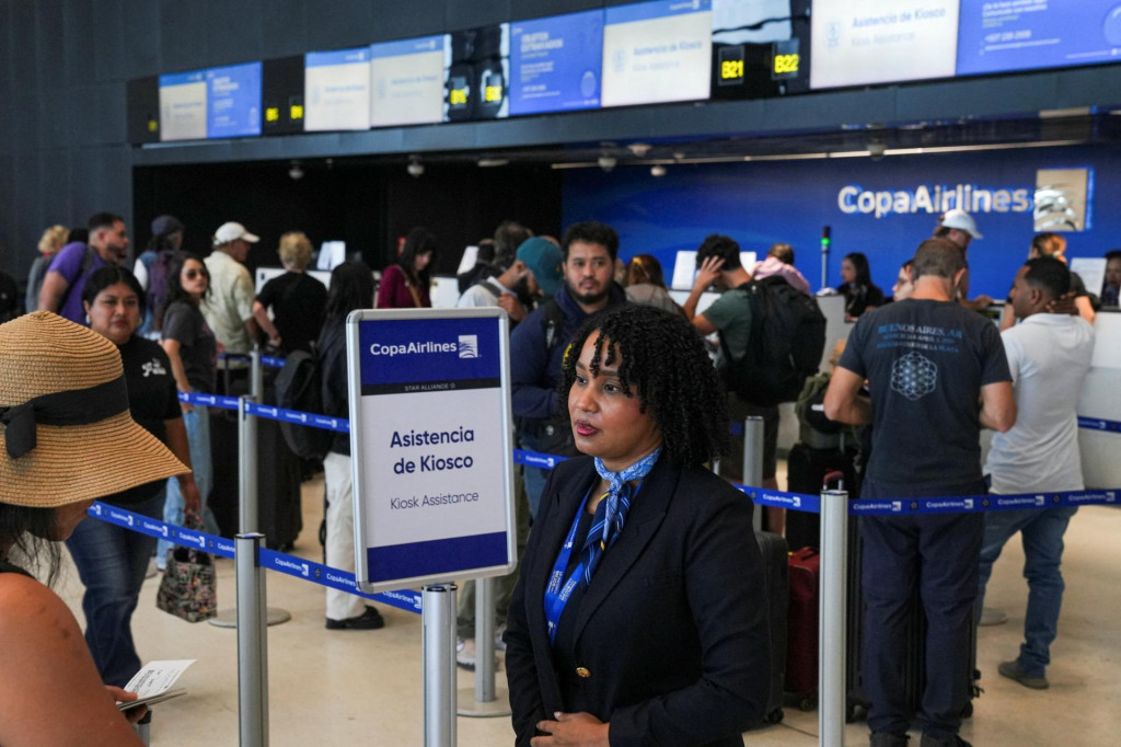 Zamestnankyňa spoločnosti Copa Airlines pomáha cestujúcim pri pulte leteckej spoločnosti na medzinárodnom letisku Tocumen po tom, čo dopravca oznámil, že pozastavuje lety do Venezuely z dôvodu občasných problémov s navigačnými signálmi hlásených pilotmi, čo viedlo k dočasnému zastaveniu letov do a z Caracasu. FOTO: Reuters