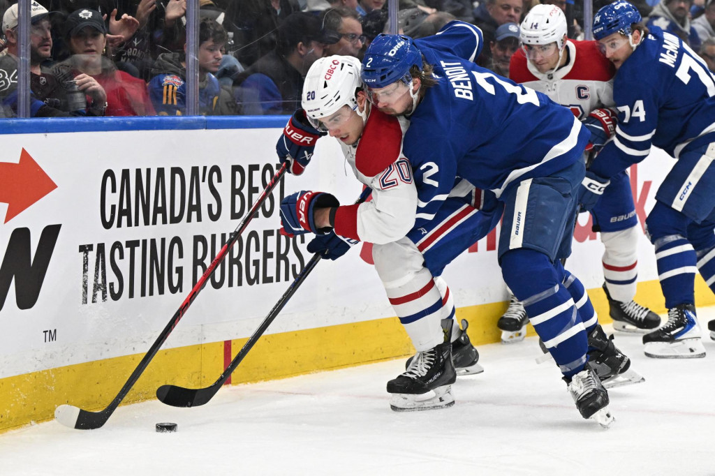 Moment zo zápasu Montreal - Toronto, v ktorom Juraj Slafkovský bojuje o puk s obrancom Toronta Simonom Benoitom (2). FOTO: Dan Hamilton-Imagn Images