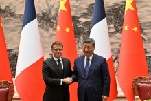 Na snímke zo 4. decembra si podávajú ruky prezidenti Číny a Francúzska Emmanuel Macron a Si Ťin-pching počas ich stretnutia v Pekingu. FOTO TASR/AP