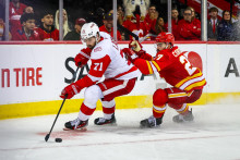 Center Detroitu Red Wings Dylan Larkin (71) a pravé krídlo Calgary Flames Matt Coronato (27) bojujú o puk počas tretej tretiny. FOTO: Sergei Belski/Imagn Images