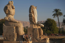Na snímke dve renovované kolosálne sochy významného faraóna Amenhotepa III., ktoré egyptské úrady predstavili v meste Luxor v nedeľu 14. decembra 2025. FOTO: TASR/AP