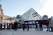 Zamestnanci m&uacute;zea Louvre držia transparent s n&aacute;pisom &bdquo;M&uacute;zeum Louvre &scaron;trajkuje&ldquo;. FOTO: Reuters