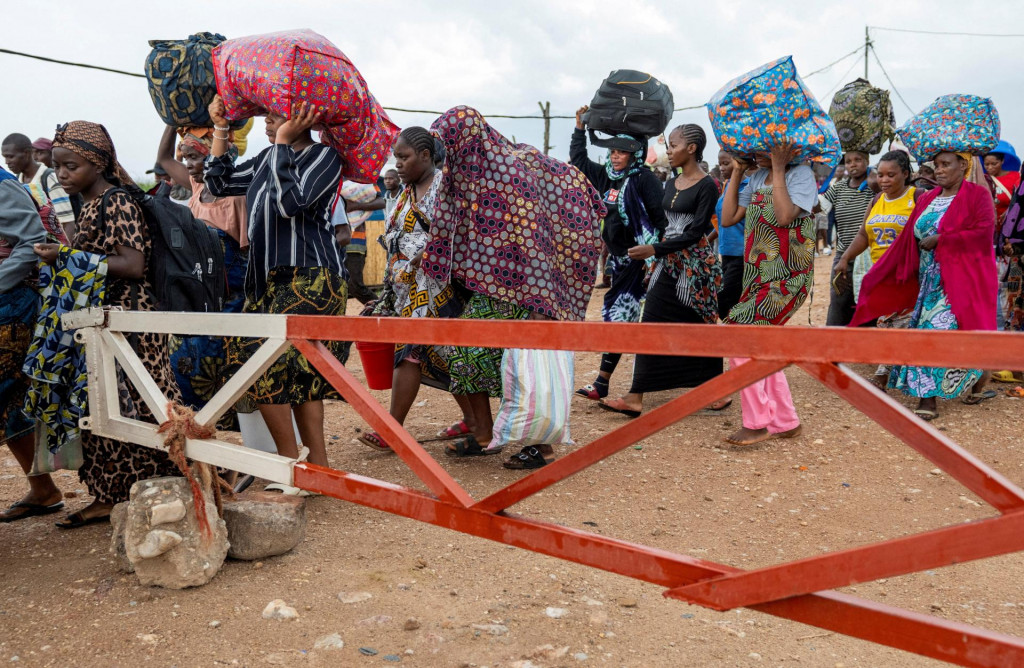 Cudzinci, ktor&iacute; uviazli počas stretov stoja v rade na prekročenie hraničn&eacute;ho priechodu v Uvire. FOTO: Reutets