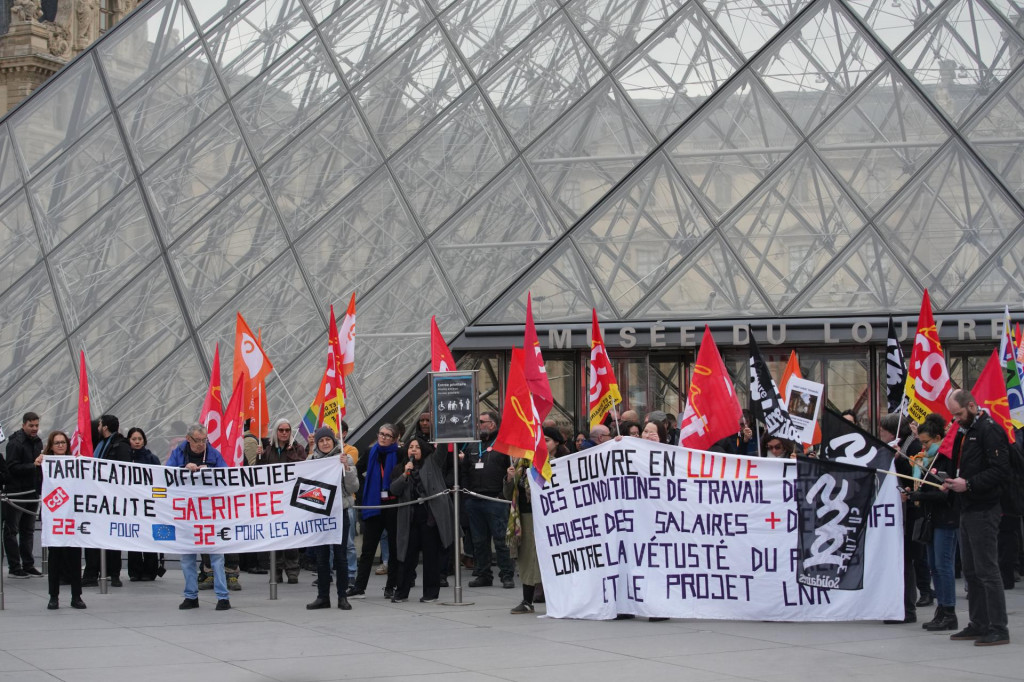 Odbor&aacute;ri držia transparent a odbor&aacute;rske z&aacute;stavy počas &scaron;trajku pred m&uacute;zeom Louvre. FOTO: TASR/AP
