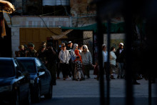 Izraelsk&iacute; vojaci so zbraňami sprev&aacute;dzaj&uacute; izraelsk&yacute;ch osadn&iacute;kov počas t&yacute;ždennej prehliadky na Izraelom okupovanom Z&aacute;padnom brehu Jord&aacute;nu. FOTO: Reuters