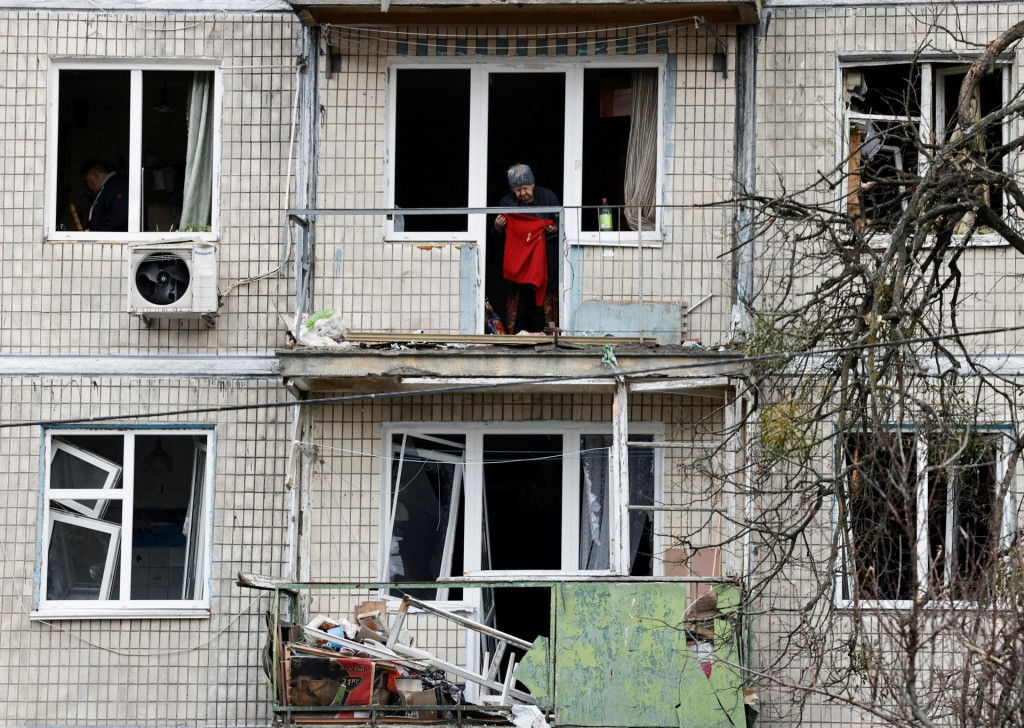 Obyvateľ stoj&iacute; v bytovom dome po&scaron;kodenom rusk&yacute;m &uacute;tokom v Kyjeve. FOTO: Reuters