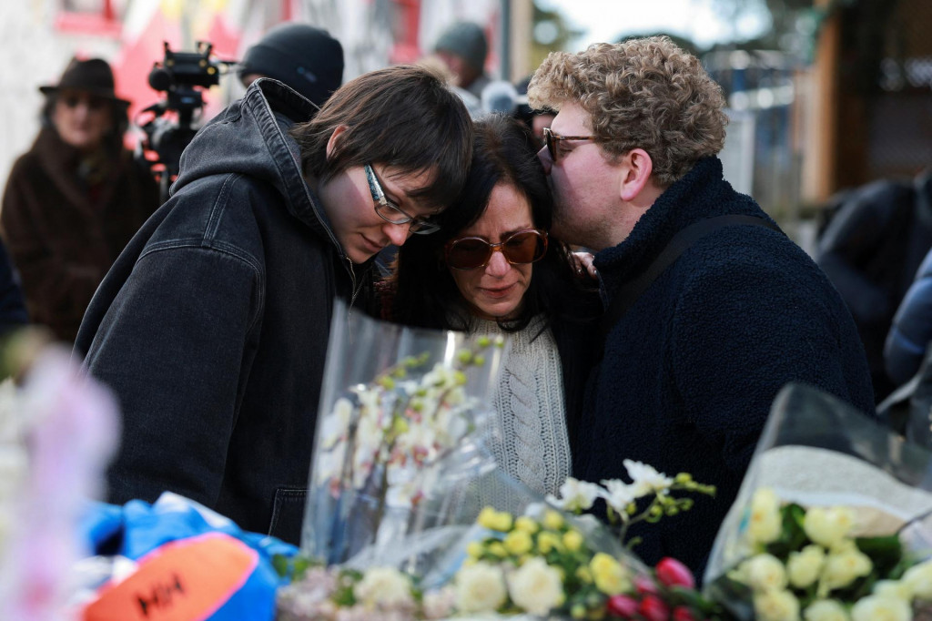 Ľudia sm&uacute;tia po požiadu baru v &scaron;vajčiarskom lyžiarskom stredisku Crans-Montana. FOTO: Reuters