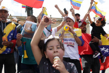 Venezuelčania žij&uacute;ci v Kolumbii držia vlajky, keď sa zhromažďuj&uacute; na n&aacute;mest&iacute; Plaza de Bolivar, aby osl&aacute;vili zatknutie venezuelsk&eacute;ho prezidenta. FOTO: REUTERS