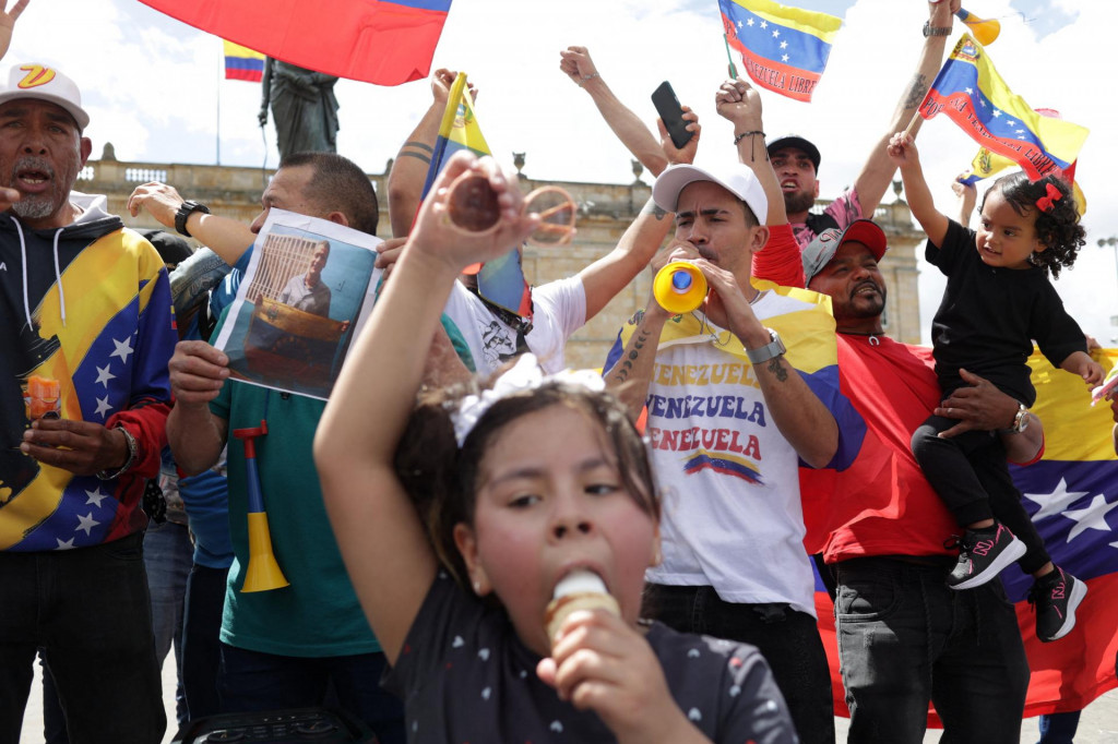 Venezuelčania žij&uacute;ci v Kolumbii držia vlajky, keď sa zhromažďuj&uacute; na n&aacute;mest&iacute; Plaza de Bolivar, aby osl&aacute;vili zatknutie venezuelsk&eacute;ho prezidenta. FOTO: REUTERS