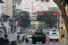 Obrnen&eacute; vozidl&aacute; n&aacute;rodnej gardy blokuj&uacute; ulicu ved&uacute;cu k prezidentsk&eacute;mu pal&aacute;cu Miraflores po v&yacute;buchoch a počut&iacute; n&iacute;zko letiacich lietadiel vo venezuelskej metropole Caracas. FOTO: TASR/AP