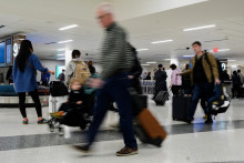 Na sn&iacute;mke cestuj&uacute;ci prech&aacute;dzaj&uacute; letiskom. FOTO TASR/AP