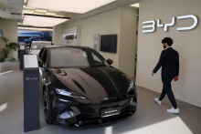 Osoba kr&aacute;ča vedľa auta BYD Seal v spoločnosti BYD Auto a predajni Autotorino v Mil&aacute;ne v Taliansku. FOTO: Reuters