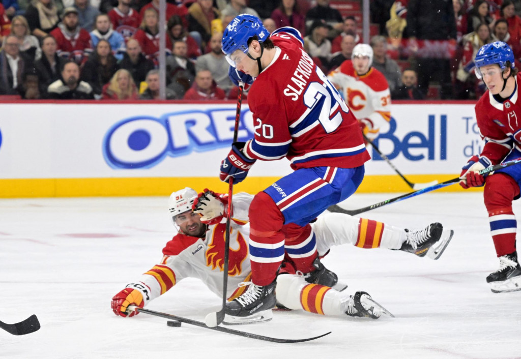 &Uacute;točn&iacute;k Montreal Canadiens Juraj Slafkovsk&yacute; (20) rozohr&aacute;va puk a &uacute;točn&iacute;k Calgary Flames Nazem Kadri (91) br&aacute;ni počas druhej tretiny. FOTO: Eric Bolte/Imagn Images