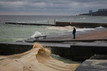 Ilustračn&aacute; fotografia. Obyvateľ stoj&iacute; na hr&aacute;dzi neďaleko &uacute;niku slnečnicov&eacute;ho oleja z pr&iacute;stavn&eacute;ho termin&aacute;lu, ktor&yacute; bol zasiahnut&yacute; ned&aacute;vnymi rusk&yacute;mi raketov&yacute;mi a dronov&yacute;mi &uacute;tokmi v Odese. FOTO: Reuters