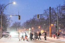 Ľudia kr&aacute;čaj&uacute; cez zasnežen&uacute; križovatku na ulici počas siln&eacute;ho sneženia v nemeckom Berl&iacute;ne. FOTO: TASR/AP