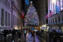Ľudia kr&aacute;čaj&uacute; okolo vianočn&eacute;ho stromu pred newyorskou burzou. FOTO: TASR/AP