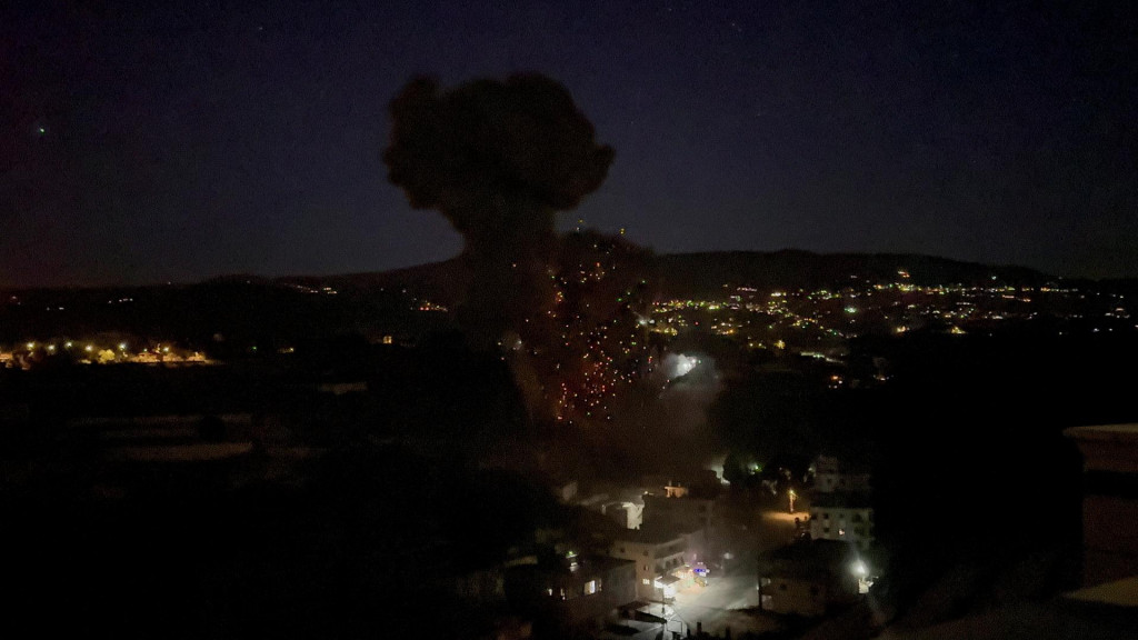 Oheň a dym st&uacute;paj&uacute; po izraelsk&yacute;ch n&aacute;letoch na Kfar Hatta v južnom Libanone. FOTO: Reuters