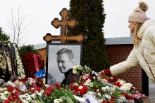 Žena na arch&iacute;vnej sn&iacute;mke z 2. marca 2024 uklad&aacute; kvety na hrob Alexeja Navaľn&eacute;ho na moskovskom Borisovskom cintor&iacute;ne. FOTO: Reuters