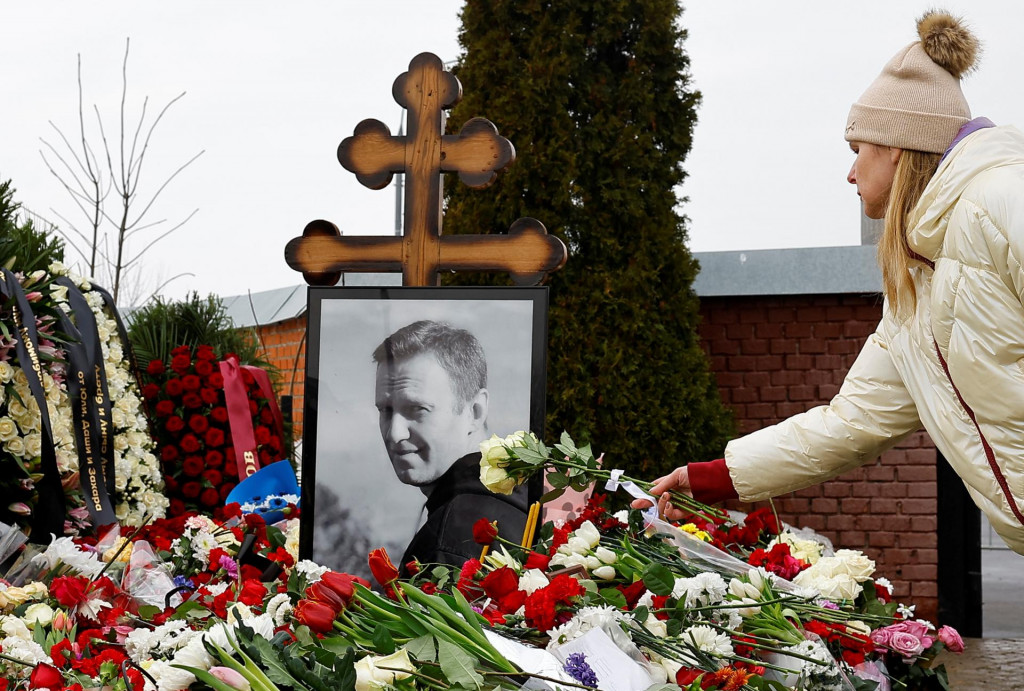 Žena na arch&iacute;vnej sn&iacute;mke z 2. marca 2024 uklad&aacute; kvety na hrob Alexeja Navaľn&eacute;ho na moskovskom Borisovskom cintor&iacute;ne. FOTO: Reuters