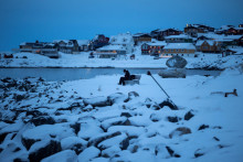 Muž sed&iacute; na lavičke pri mori v starom pr&iacute;stave mesta Nuuk v Gr&oacute;nsku. FOTO: REUTERS