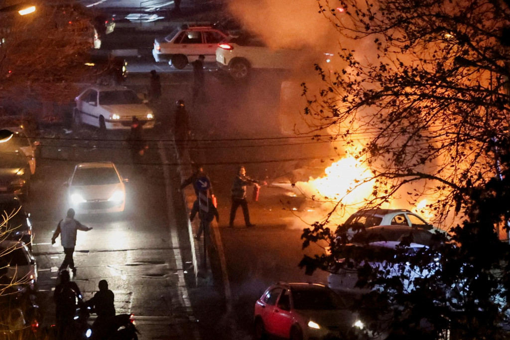 Požiar na ulici počas protestu v Teher&aacute;ne. FOTO: Reuters