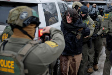 Agenti americkej pohraničnej hliadky spolupracuj&uacute;ci s veliteľom pohraničnej hliadky zadržiavaj&uacute; demon&scaron;tranta v Minneapolise. FOTO: Reuters