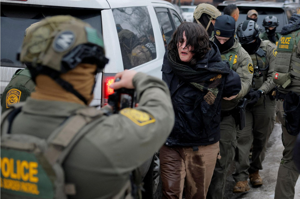Agenti americkej pohraničnej hliadky spolupracuj&uacute;ci s veliteľom pohraničnej hliadky zadržiavaj&uacute; demon&scaron;tranta v Minneapolise. FOTO: Reuters