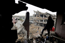 Palest&iacute;nčania si prezeraj&uacute; miesto izraelsk&eacute;ho &uacute;toku na dom v centr&aacute;lnom P&aacute;sme Gazy. FOTO: Reuters