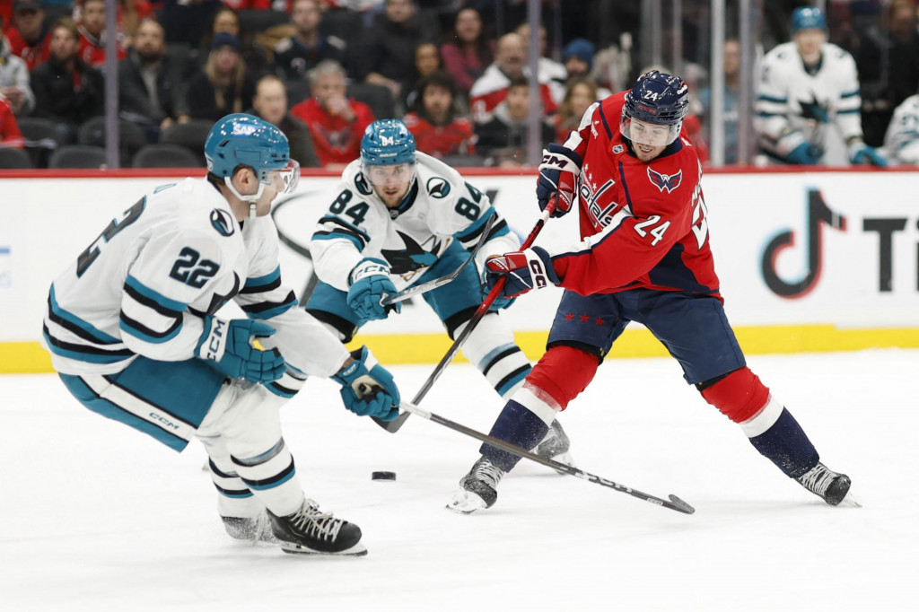 Center Washington Capitals Connor McMichael, obranca San Jose Sharks Vincent Iorio a ľav&eacute; kr&iacute;dlo Sharks Pavol Regenda. FOTO: Reuters/Geoff Burke-Imagn Images