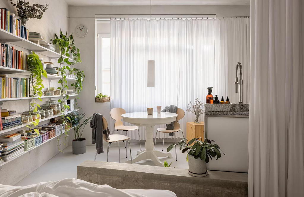 Sp&aacute;lňa už nie je lemovan&aacute; sklenenou tehlovou stenou, ale pokračuje bet&oacute;nov&yacute;m podstavcom v podobe steny na sedenie a z&aacute;vesom, ktor&yacute; nen&aacute;padne naznačuje, že sa nach&aacute;dzame v int&iacute;mnej&scaron;ej časti bytu. FOTO: Matej Hak&aacute;r