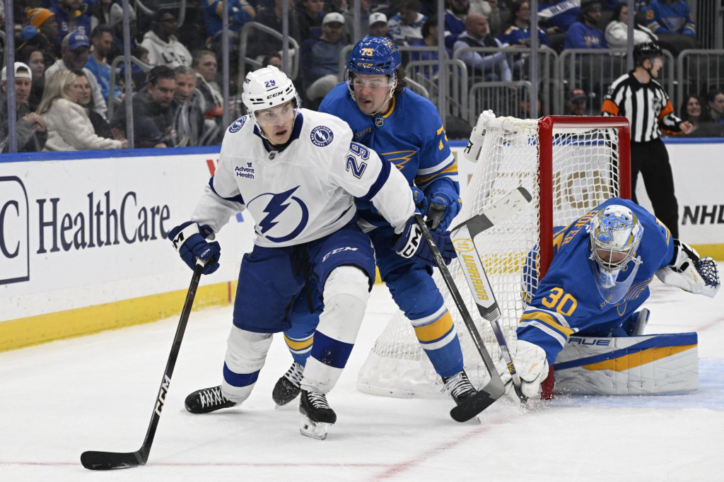 Brank&aacute;r t&iacute;mu St. Louis Blues Joel Hofer (30) a obranca Tyler Tucker (75) br&aacute;nia sieť proti prav&eacute;mu kr&iacute;deln&iacute;kovi t&iacute;mu Tampa Bay Lightning Pontusovi Holmbergovi (29) počas tretej tretiny. FOTO: Jeff Le/Imagn Images