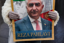 Protestuj&uacute;ci drž&iacute; transparent s vyobrazen&iacute;m Rezu Pahlav&iacute;ho, exilov&eacute;ho syna posledn&eacute;ho ir&aacute;nskeho &scaron;&aacute;ha a ir&aacute;nskej opozičnej osobnosti. FOTO: Reuters